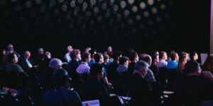 crowd of people sitting on chairs inside room